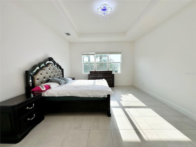 bedroom with light tile patterned floors, baseboards, visible vents, and a raised ceiling