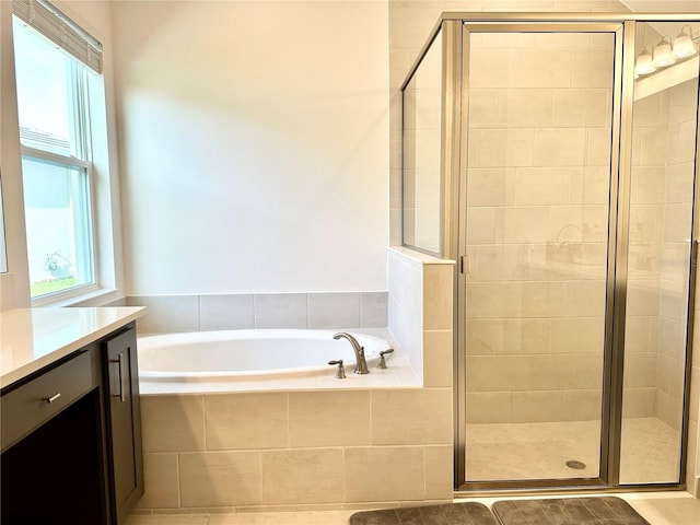 full bath with a wealth of natural light, a garden tub, and a shower stall