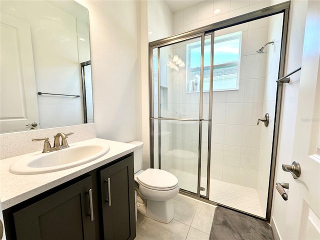 full bathroom featuring tile patterned flooring, a shower stall, toilet, and vanity