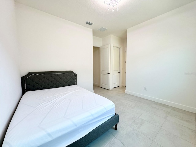 bedroom featuring a textured ceiling, visible vents, and baseboards