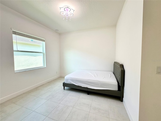 bedroom with a textured ceiling and baseboards