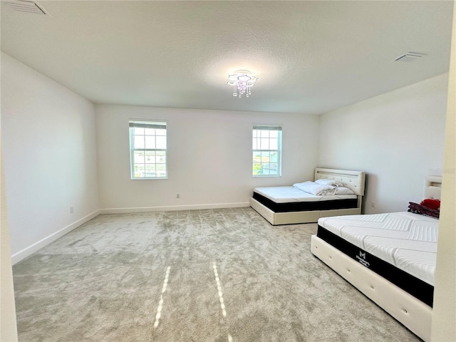 bedroom featuring multiple windows, visible vents, and carpet flooring