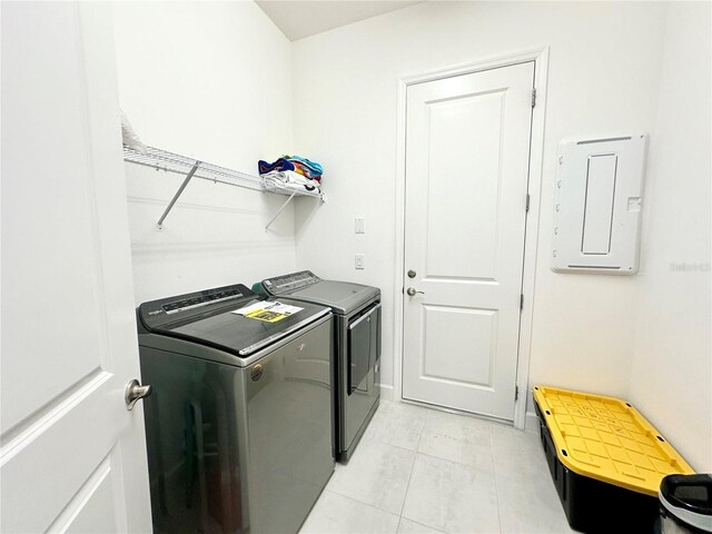 laundry area featuring light tile patterned floors, laundry area, independent washer and dryer, and electric panel