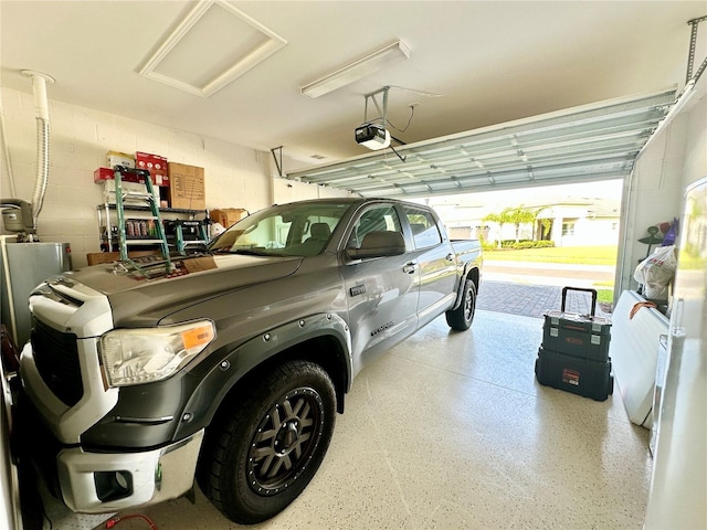 garage with concrete block wall and a garage door opener