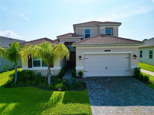 mediterranean / spanish-style house with stone siding, decorative driveway, a front lawn, and a garage