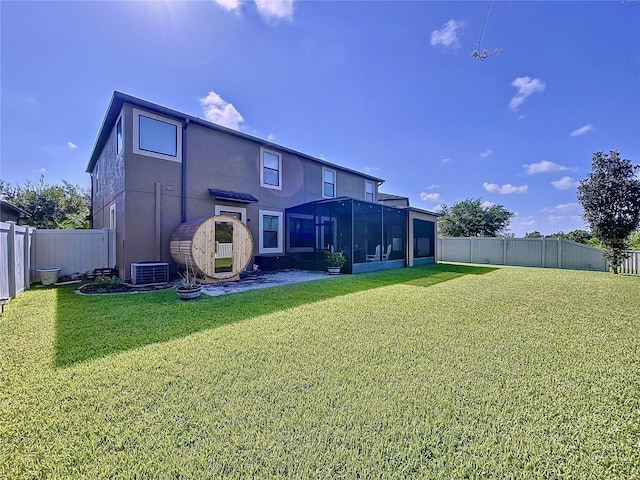 rear view of property featuring a yard, stucco siding, a sunroom, central AC, and a fenced backyard