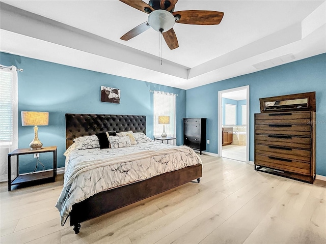 bedroom with ceiling fan, ensuite bath, and light hardwood / wood-style floors