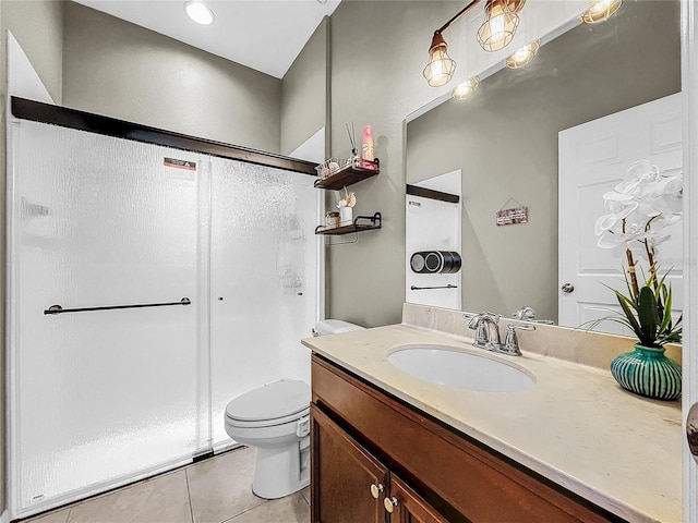 bathroom with vanity, a shower with door, toilet, and tile patterned floors