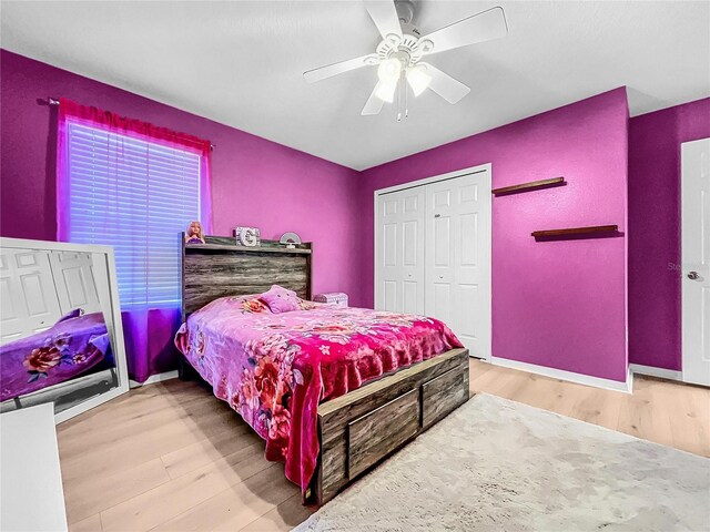 bedroom with ceiling fan, a closet, and light hardwood / wood-style flooring