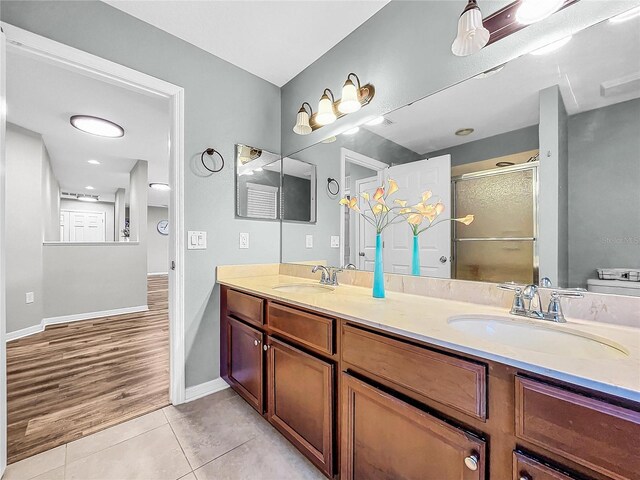 bathroom featuring dual vanity, hardwood / wood-style floors, and toilet