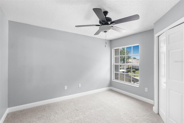 interior space with ceiling fan, a textured ceiling, and carpet floors