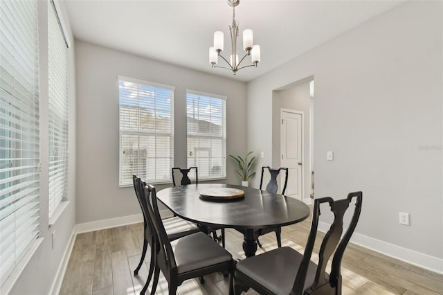 dining room featuring light wood-type flooring and a notable chandelier