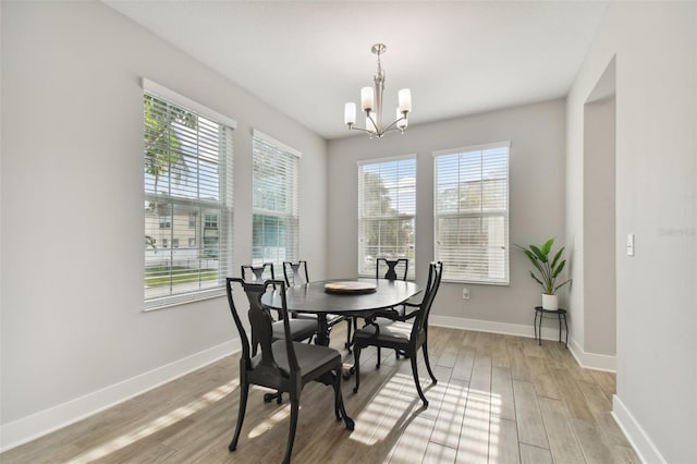 dining area with an inviting chandelier and light hardwood / wood-style floors