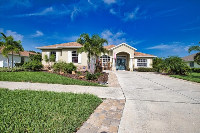 view of front facade with french doors, a front lawn, and stucco siding