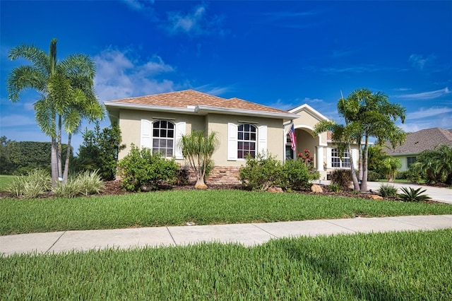 view of front of property with concrete driveway, a front lawn, and stucco siding