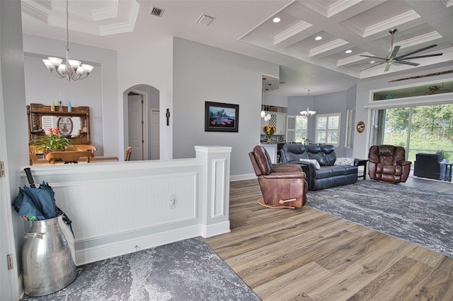 living area with coffered ceiling, visible vents, and wood finished floors