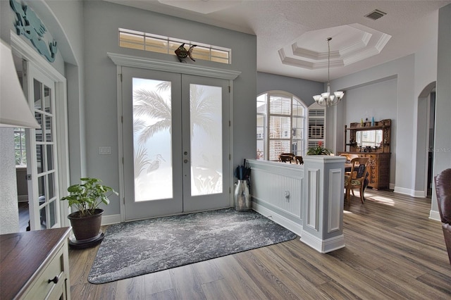 doorway to outside with a tray ceiling, french doors, wood finished floors, and visible vents