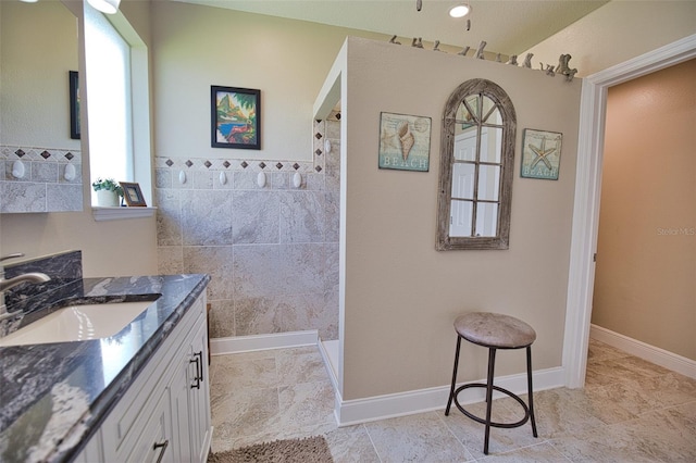 bathroom with vanity, baseboards, and walk in shower