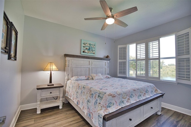 bedroom with ceiling fan, baseboards, and wood finished floors