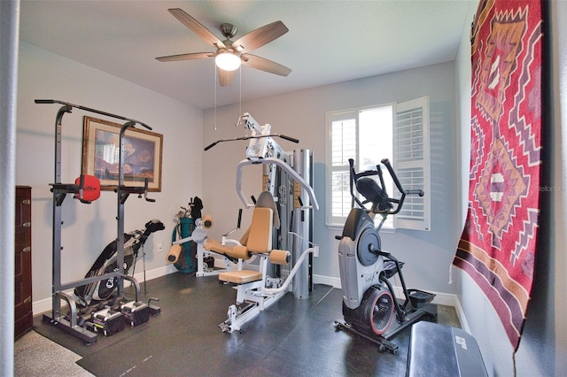 exercise room with ceiling fan and baseboards