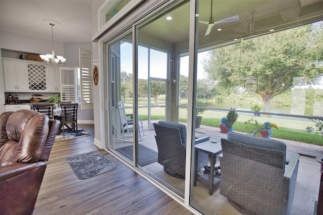 sunroom with ceiling fan with notable chandelier