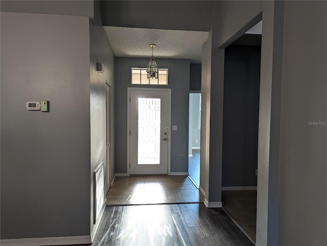 foyer featuring a textured ceiling and dark wood-type flooring