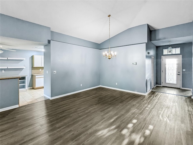 unfurnished dining area featuring hardwood / wood-style flooring, vaulted ceiling, and an inviting chandelier