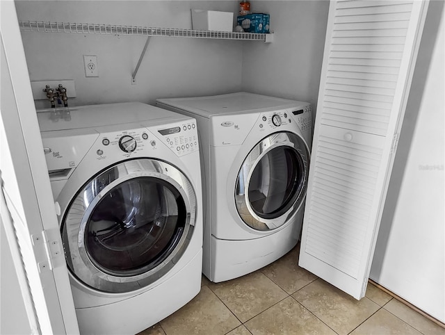 laundry area with washer and dryer and light tile patterned floors