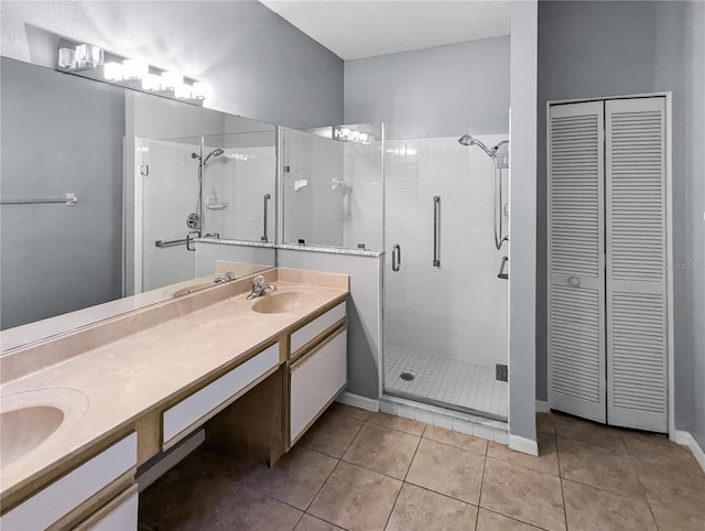 bathroom featuring tile patterned flooring, vanity, and a shower with shower door