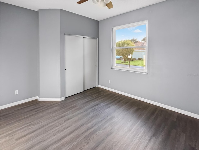 unfurnished bedroom featuring dark hardwood / wood-style flooring, a closet, and ceiling fan