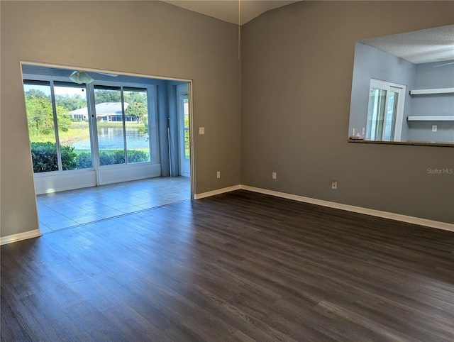 empty room with a textured ceiling, ceiling fan, lofted ceiling, and hardwood / wood-style flooring