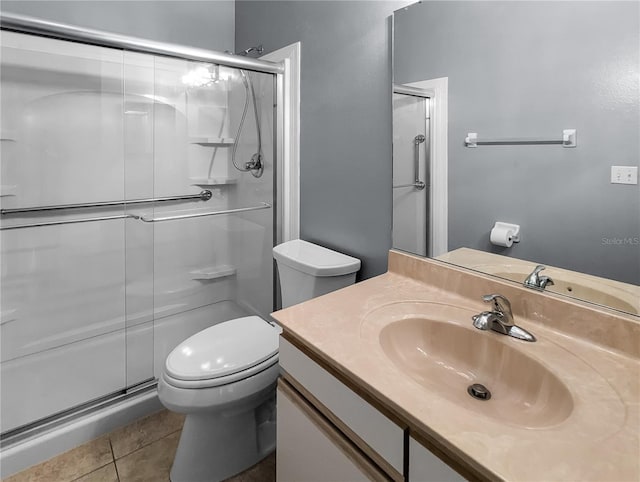 bathroom with tile patterned flooring, vanity, a shower with door, and toilet