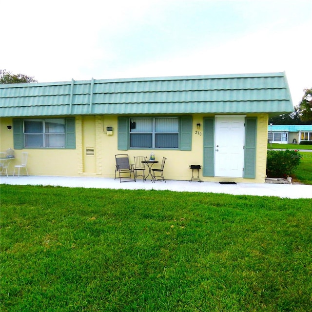 back of property with a patio area and a lawn