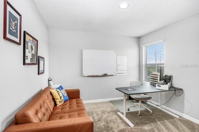 carpeted office featuring a textured ceiling