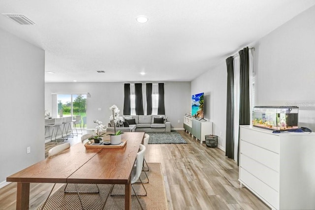 dining space with light hardwood / wood-style flooring