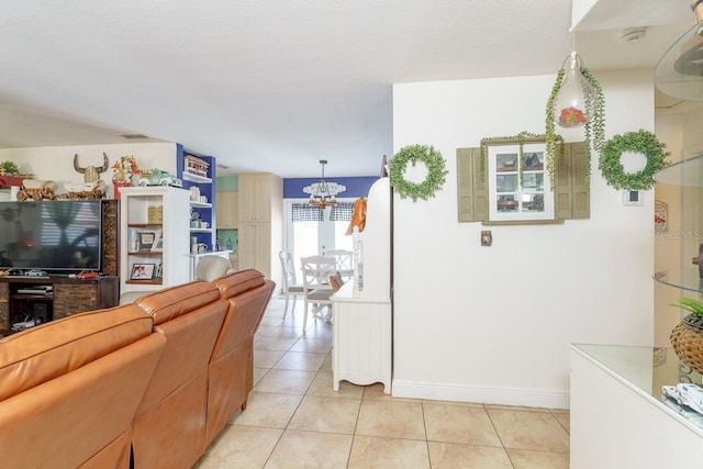 living room featuring a chandelier, light tile patterned flooring, and baseboards