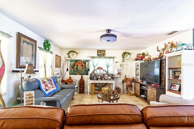 living room with light tile patterned floors, visible vents, and a textured ceiling