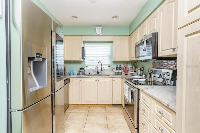 kitchen with tasteful backsplash, stainless steel appliances, light countertops, a sink, and light tile patterned flooring