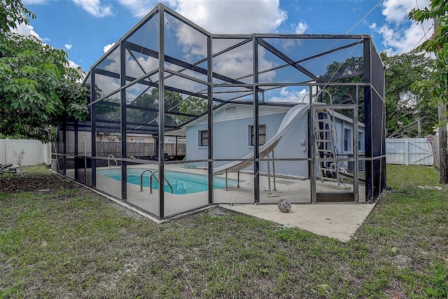 rear view of property with a patio, a fenced in pool, glass enclosure, and a yard