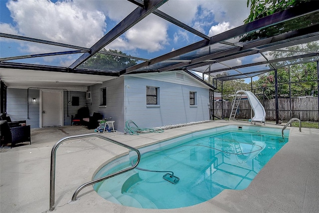 view of swimming pool with a patio, a water slide, and a lanai