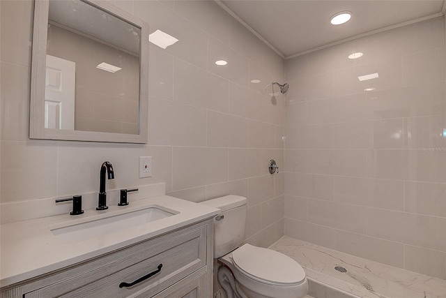 bathroom featuring tile walls, vanity, a tile shower, and toilet