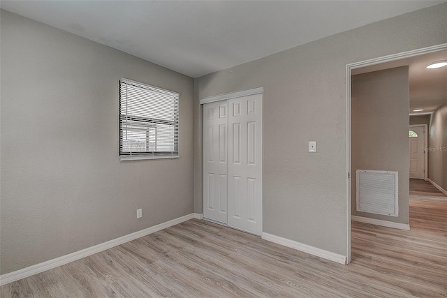 unfurnished bedroom featuring a closet and light wood-type flooring