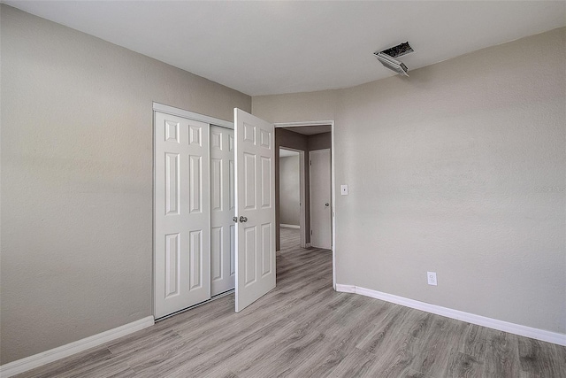 unfurnished bedroom featuring a closet and light wood-type flooring