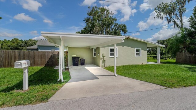 view of front of property featuring a carport and a front lawn