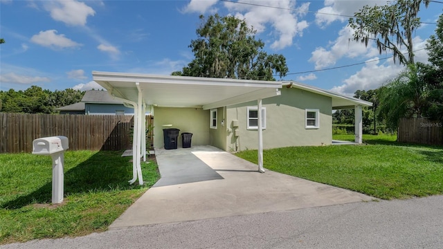 view of front of property with a carport, a front yard, concrete driveway, and stucco siding