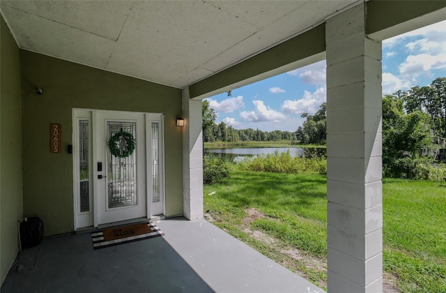 property entrance with a water view and a yard