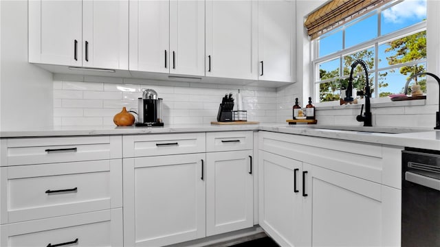 bar with black dishwasher, backsplash, and a sink