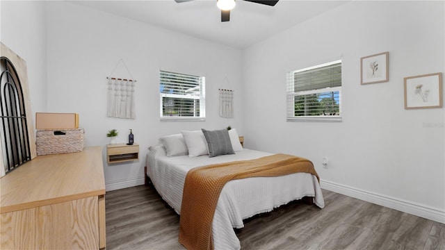 bedroom with ceiling fan, baseboards, and wood finished floors