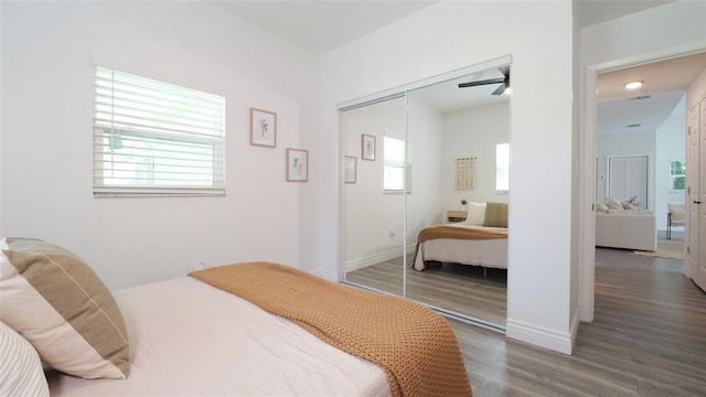 bedroom with a closet, baseboards, and wood finished floors