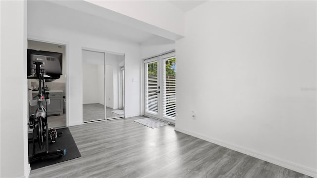 interior space featuring baseboards, wood finished floors, and french doors